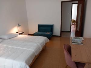 - une chambre avec un lit, un bureau et une chaise dans l'établissement Home Poetry_La Spezia_Cinque Terre, à La Spezia