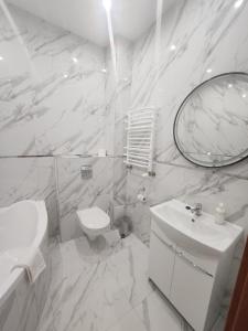 a white bathroom with a sink and a mirror at Hotel Dowhań in Nowe