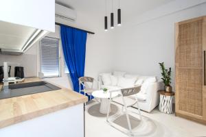 a kitchen and living room with a table and chairs at Georgia apartments and suites in town in Skiathos