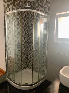 a glass shower in a bathroom with a sink at Retiro das Bananeiras in Horta