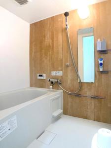 a bathroom with a bath tub and a mirror at guesthouse築港 in Osaka