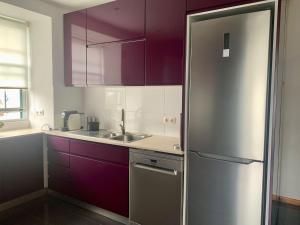 a kitchen with purple cabinets and a stainless steel refrigerator at Retiro das Bananeiras in Horta