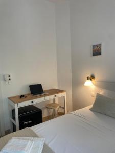 a bedroom with a bed and a desk with a laptop at Hotel Elite in Cervia