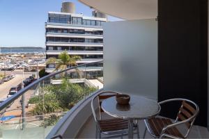 a table and chairs on a balcony with a view of a city at Oceana Suites en SeaPort, vista al mar in Punta del Este