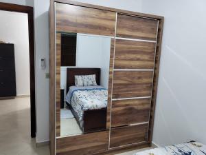 a large wooden closet in a bedroom with a bed at Zemmouri in Tangier