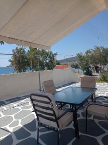 Selínia的住宿－Theatraki，露台上的桌椅和遮阳伞