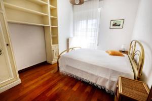 1 dormitorio con cama blanca y suelo de madera en Il lupo e la volpe - parcheggio gratis, en Centobuchi
