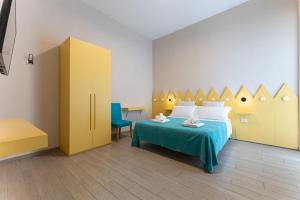 a bedroom with a bed with a blue table and yellow cabinets at Oceano Rooms in Termoli