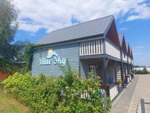 a blue building with a blue sky sign on it at Domki Letniskowe Blue Sky 2 in Rewal