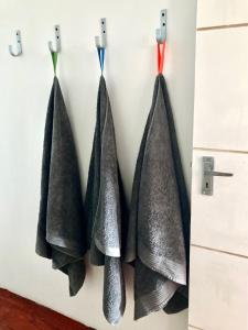 four black towels hanging on a wall at Loft on Long in Hermanus