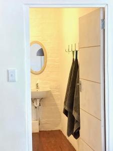 a bathroom with a sink and a towel rack at Loft on Long in Hermanus