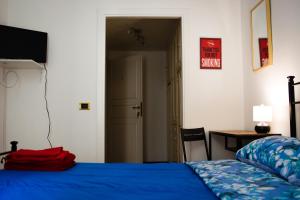a bedroom with a blue bed and a desk and a table at Praty Rooms in Rome