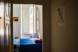 a bedroom with a blue bed and a window at Praty Rooms in Rome
