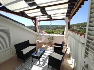 a balcony with chairs and a table and a view at Lopar Lidija in Lopar