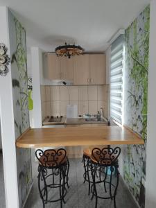 a kitchen with a wooden table and two stools at Apartman Kuč Divcibare in Divčibare