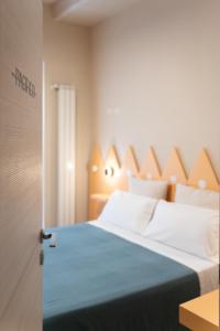 a bedroom with a bed with a wooden headboard at Oceano Rooms in Termoli
