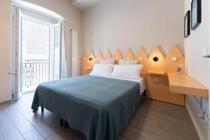 a bedroom with a bed with a blue blanket and a window at Oceano Rooms in Termoli