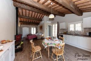 cocina y comedor con mesa y sillas en La casa delle Rondini, en Forcoli