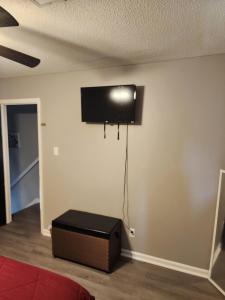 een kamer met een flatscreen-tv aan de muur bij Monticello BnB in North Little Rock