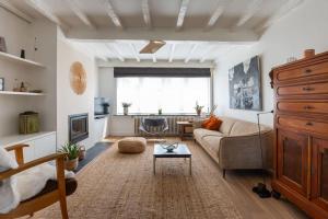 uma sala de estar com um sofá e uma mesa em Gezellig huisje met leuke tuin em De Haan