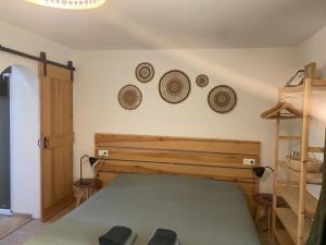 ein Schlafzimmer mit einem Bett und ein paar Hüte an der Wand in der Unterkunft L'Océanaise in Soulac-sur-Mer