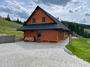 a large wooden cabin with a gambrel roof at Chata Planina in Michalová