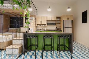 a kitchen with a green counter and stools at Comfy Loft in Santa Ana in Santa Pera