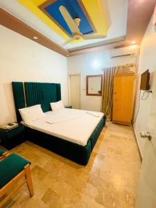 Rehaish Inn في كراتشي: غرفة نوم مع سرير بسقف