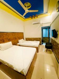 Rehaish Inn في كراتشي: غرفة نوم بسريرين ومروحة سقف