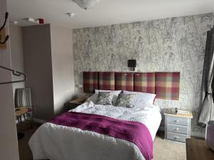 a bedroom with a bed with a purple blanket at The Dove Inn in Alburgh