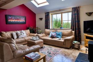 a living room with a couch and a tv at Finest Retreats - Skyview Lodge in Eglwys-Fâch