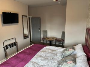 a bedroom with a bed and a tv on the wall at The Dove Inn in Alburgh