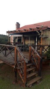 a house with a wooden deck with chairs on it at Kaltenbach Cottages in Magoebaskloof