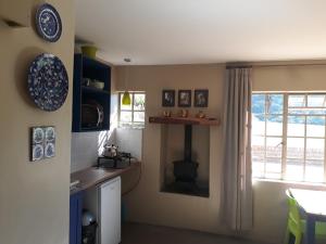 eine Küche mit einer Theke, einem Waschbecken und einem Fenster in der Unterkunft Kaltenbach Cottages in Magoebaskloof