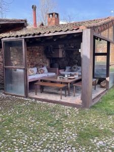 einem Holzpavillon mit Bänken und Tischen vor einem Gebäude in der Unterkunft Stunning 7-Bed House in Madriguera in Madriguera