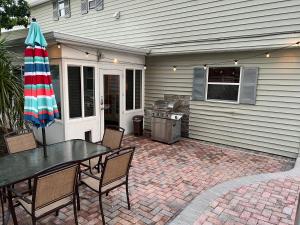 a patio with a table and an umbrella at Poolside Paradise & Beach Bound in Seminole