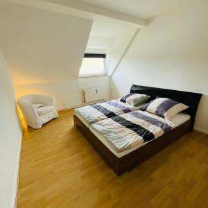 a bedroom with a bed and a chair in it at Nette Kuschelige Wohnung 2 in Bochum