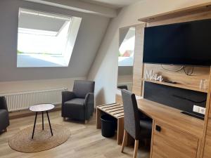 uma sala de estar com uma mesa e uma televisão de ecrã plano em Hotel Preyt -Self Check In- em Holtlander Nücke