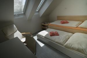 Habitación pequeña con 2 camas y escritorio. en Centrum Salvator en Bratislava