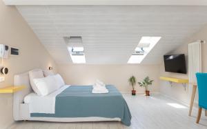 a bedroom with a bed and a tv and skylights at Oceano Rooms in Termoli