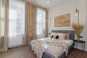 a bedroom with a large bed and two windows at FREE PARKING Old Town Central Station Apart with Balcony in Vilnius