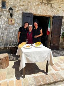 a group of three people standing around a table at Agriturismo Il Geranio in Piccione