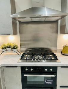 a stove top oven in a kitchen at Stylish New Built in Manchester