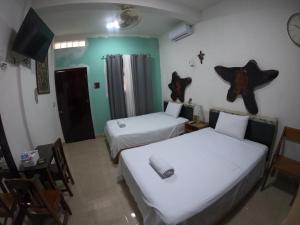 a room with two beds and a table and chairs at M&F Hotel in Bacalar +30 photos
