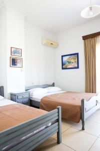 a hotel room with two beds and a window at Villa Moras in Paralia Katerinis