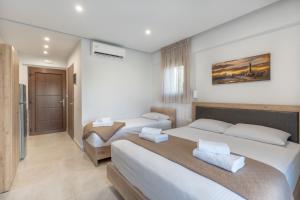 um quarto de hotel com duas camas e uma casa de banho em Sunshine Rooms and Suites em Nea Vrasna