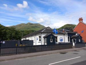 Un bâtiment blanc avec une étoile bleue en haut dans l'établissement Coe Pod, West Highland Way Holidays, à Kinlochleven