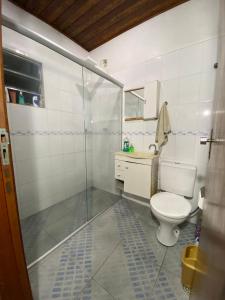 a bathroom with a toilet and a glass shower at Quarto com banheiro privativo Vibra e Transamerica SP in Sao Paulo