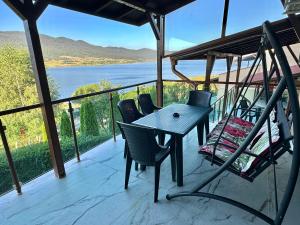- une table et des chaises sur une terrasse couverte offrant une vue sur l'eau dans l'établissement VIP Complex, à Sarnitsa