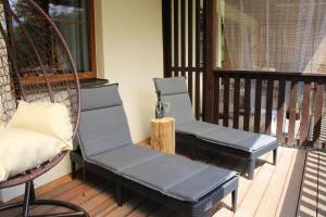 a porch with two chairs and a swing at Resort Lesní Lázně in Zvánovice +55 photos